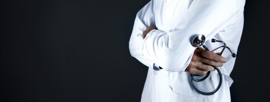 A doctor in a white coat holding a stethoscope